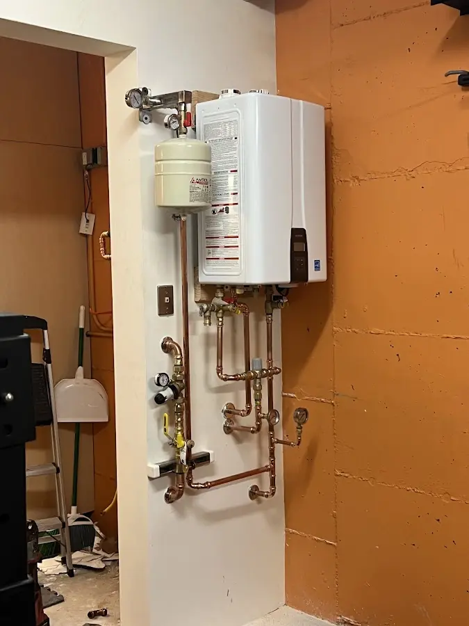 Plumbing technician inspecting water heater connections in Parker